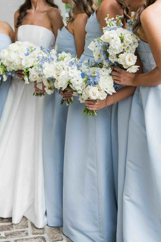 Woman wearing dusty blue strapless pleated A-line bridesmaid dress