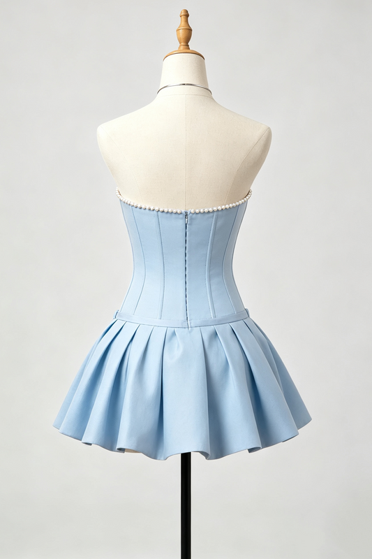 A light blue strapless corset-style homecoming dress with a pleated skirt, displayed on a cream dress form mannequin against a light gray studio background.