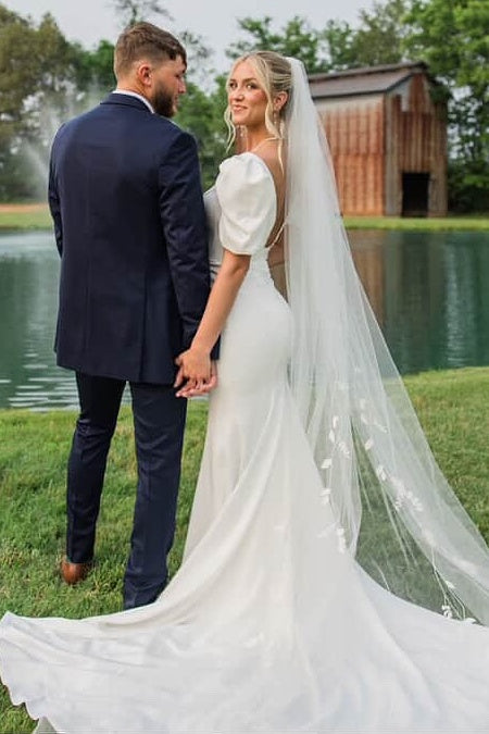 Back view of ivory puff sleeve fit and flare wedding dress with train