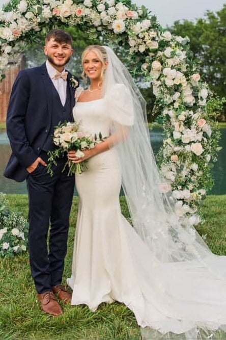 Side view of ivory fit and flare wedding dress with puff sleeves