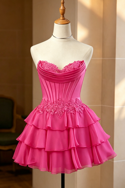 A hot pink strapless homecoming dress with a strapless neckline, lace applique, and tiered ruffle skirt.