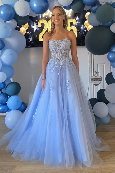 A woman wearing a strapless blue tulle ball gown with a beaded corset bodice.