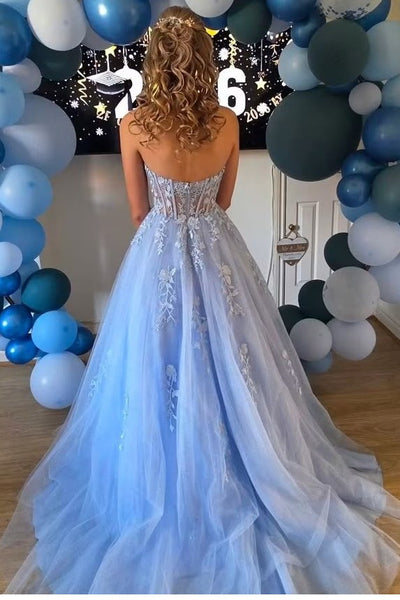 A woman wearing a strapless blue tulle ball gown with a beaded corset bodice.