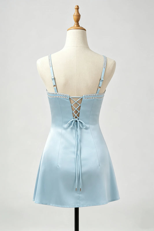A light blue satin slip dress with thin straps, a lace-up back, and a tie-front bow, displayed on a cream mannequin against a light gray background.
