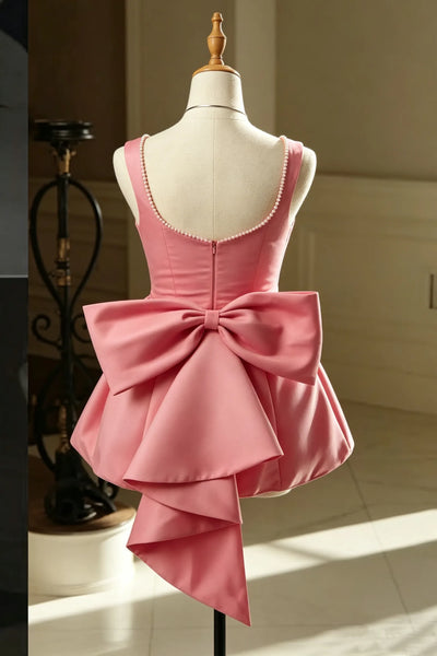 A sleeveless pink satin dress displayed on a cream mannequin torso in an indoor room with paneled walls and tiled floor.