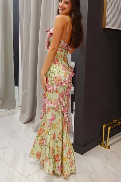 Woman wearing a floral dress standing against a neutral background