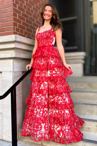 Woman wearing red lace spaghetti strap tiered ruffle high slit prom evening gown