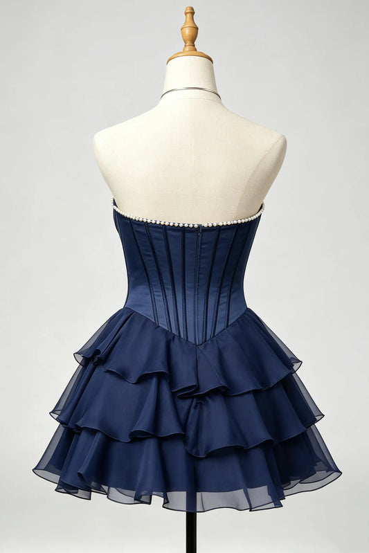 A navy blue strapless corset homecoming dress displayed on a cream mannequin torso against a light gray studio background.