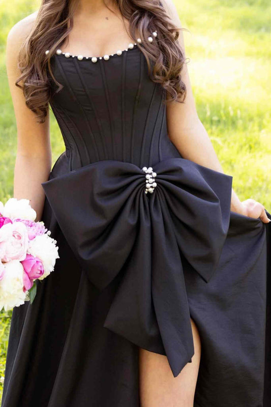 Close-up of rhinestone embellishments and bow detail on black dress