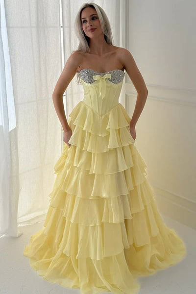 Woman wearing a mint green strapless dress with ruffled layers in a room.