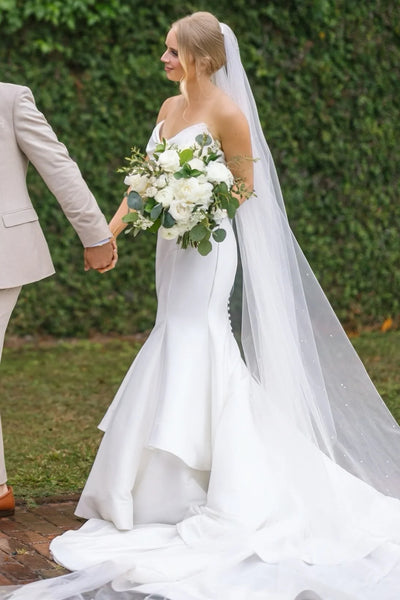 V-neck satin mermaid wedding dress with layered skirt and chapel train